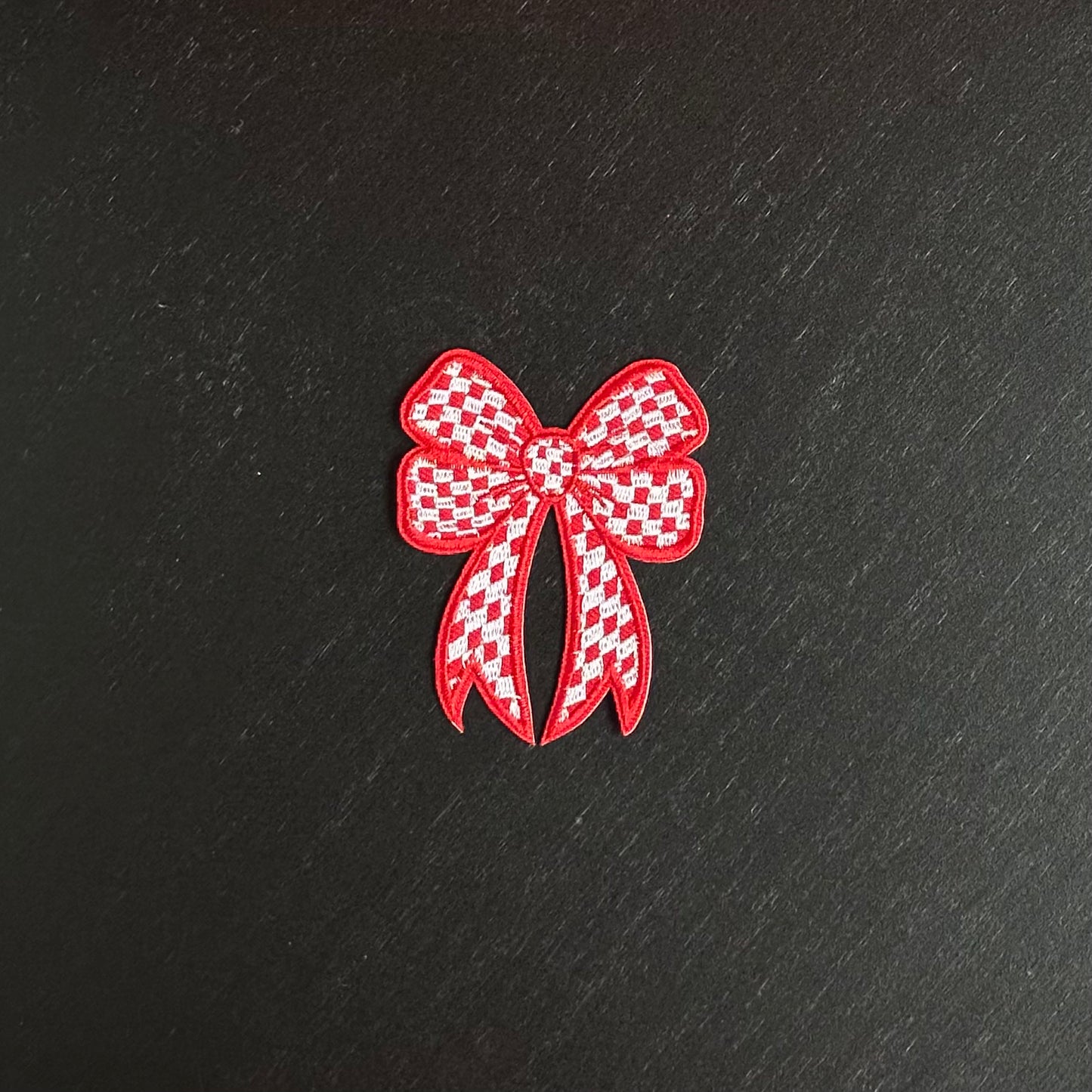 Een rood-wit geblokt strikje, met een rode omlijning. Ookwel een brabants strikje embleem.