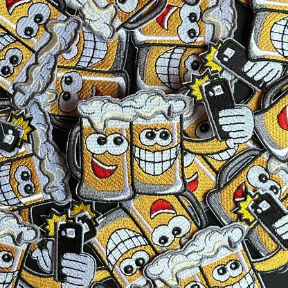 Dit embleem laat twee biertjes zien die samen een vrolijke selfie nemen met een telefoon.