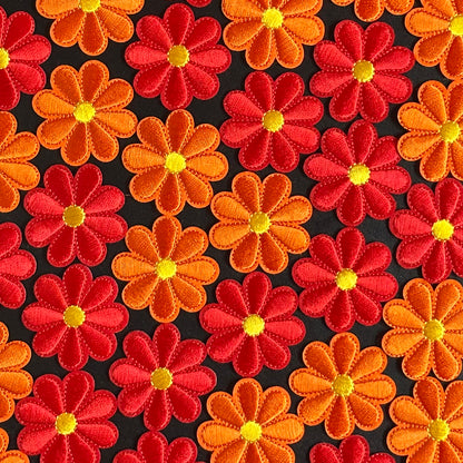 Een klein Bloemvormig Kielegat embleem in de kleuren rood of oranje.