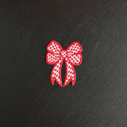 Een rood-wit geblokt strikje, met een rode omlijning. Ookwel een brabants strikje embleem.