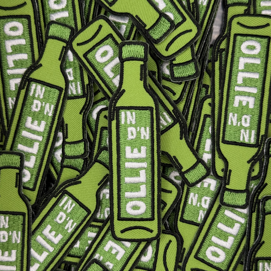 Embleem olie fles met tekst "In d'n ollie"