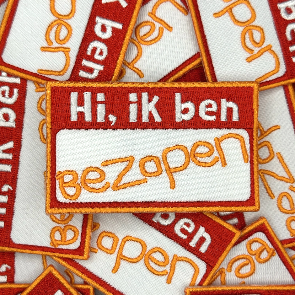 Embleem met text: "Hi, ik ben bezopen", groepsfoto