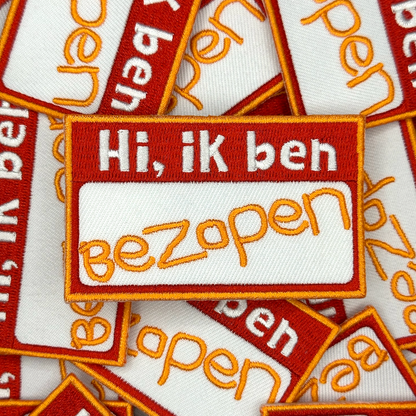 Embleem met text: "Hi, ik ben bezopen", groepsfoto