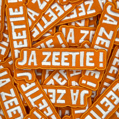Embleem met text: "Ja Zeetie!", groepsfoto