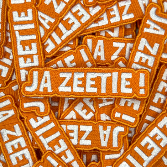 Embleem met text: "Ja Zeetie!", groepsfoto